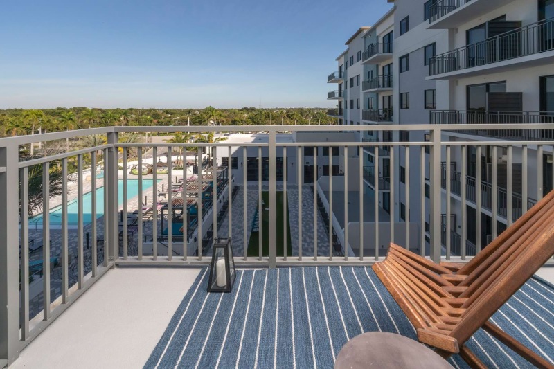 a deck with a railing and a body of water in the background