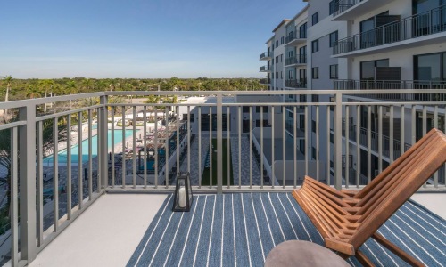 Generous balconies balcony with chair overlooking pool